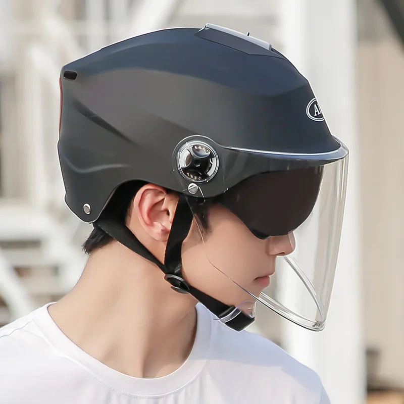 Person wearing a dark blue helmet with a clear visor outdoors