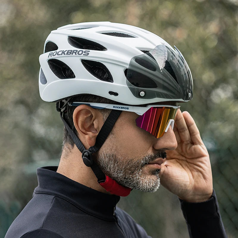 Person wearing a white ROCKBROS helmet with colorful sunglasses on a blurred natural background